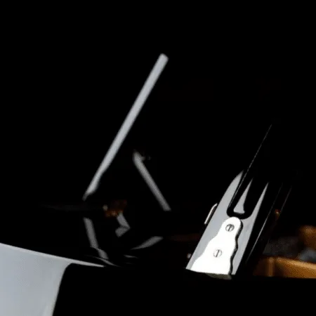 Close-up of a guitar bridge and strings against a dark background.