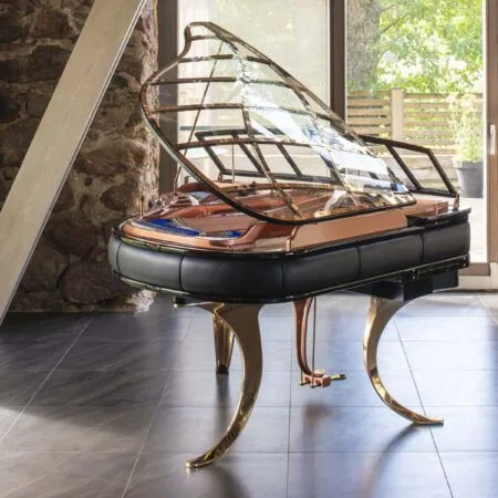 Elegant grand piano with raised lid in a sunlit room.