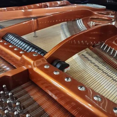 Close-up view of the intricate strings and wooden frame inside a grand piano.