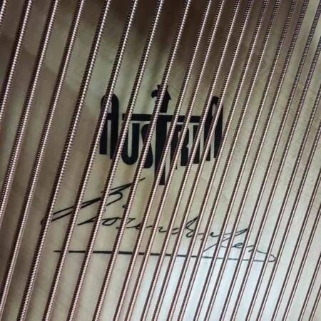 Close-up of strings and logo inside a Husqvarna piano.