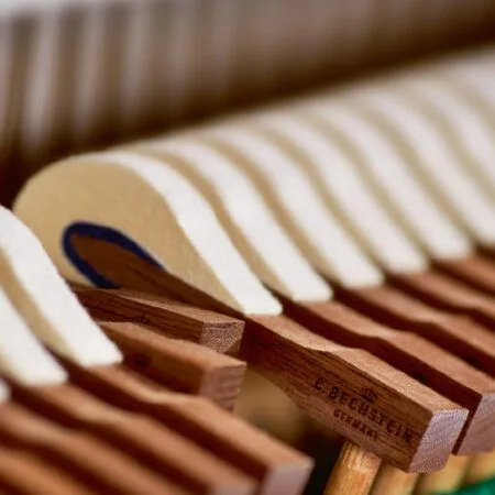 Close-up of wooden piano hammers inside a piano.