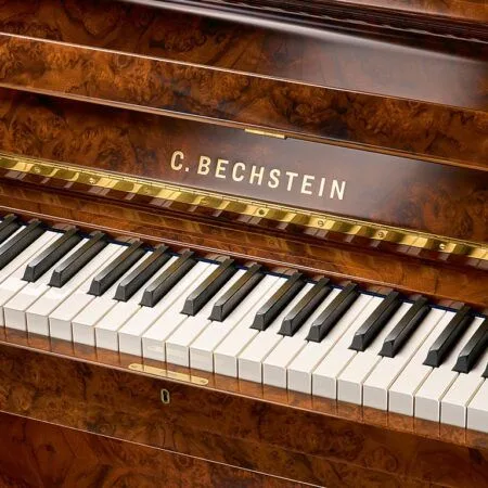 Close-up of a C. Bechstein piano keyboard with polished wooden finish.