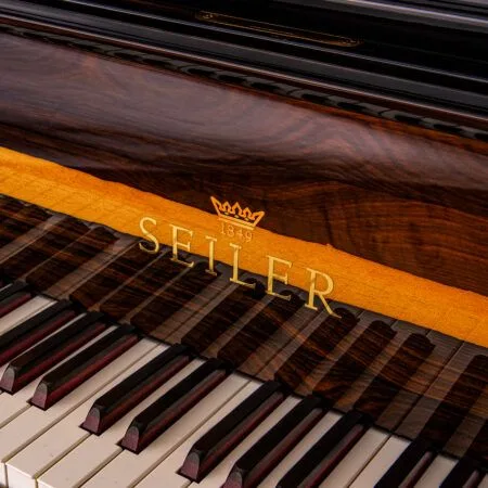 Close-up of Seiler piano keys and wood finish.