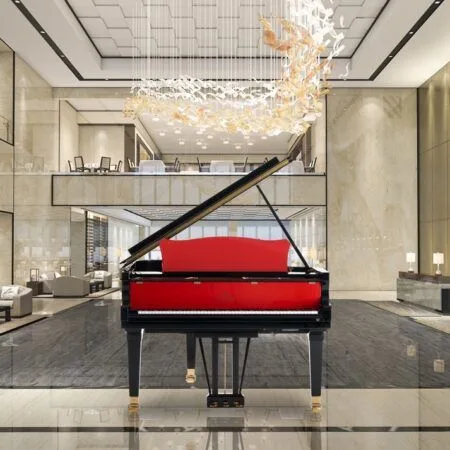 Elegant black grand piano with a striking red interior in a luxurious modern lobby.
