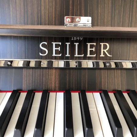 Close-up of Seiler piano keys and brand name.
