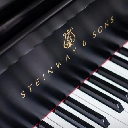 Close-up of Steinway & Sons piano keys and logo.