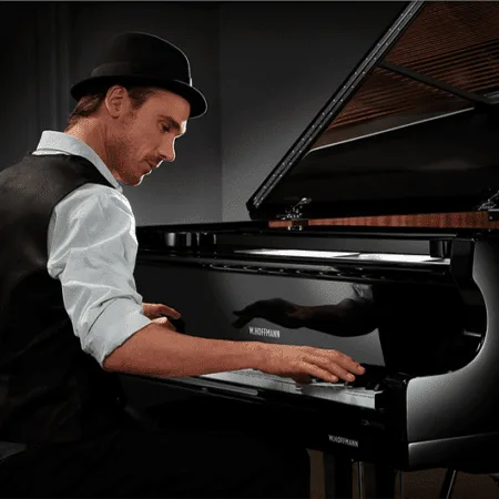 Man in hat playing a grand piano.