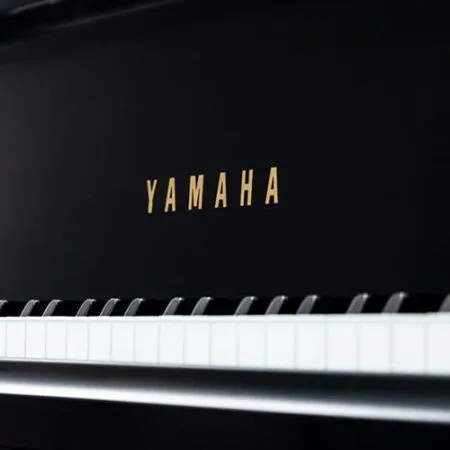 Close-up of a Yamaha piano keyboard and logo.