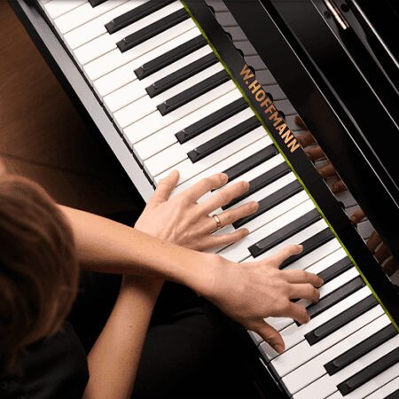 Hands playing a Steinway & Sons grand piano.