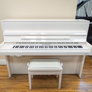 A white upright piano with a matching bench on a wooden floor.