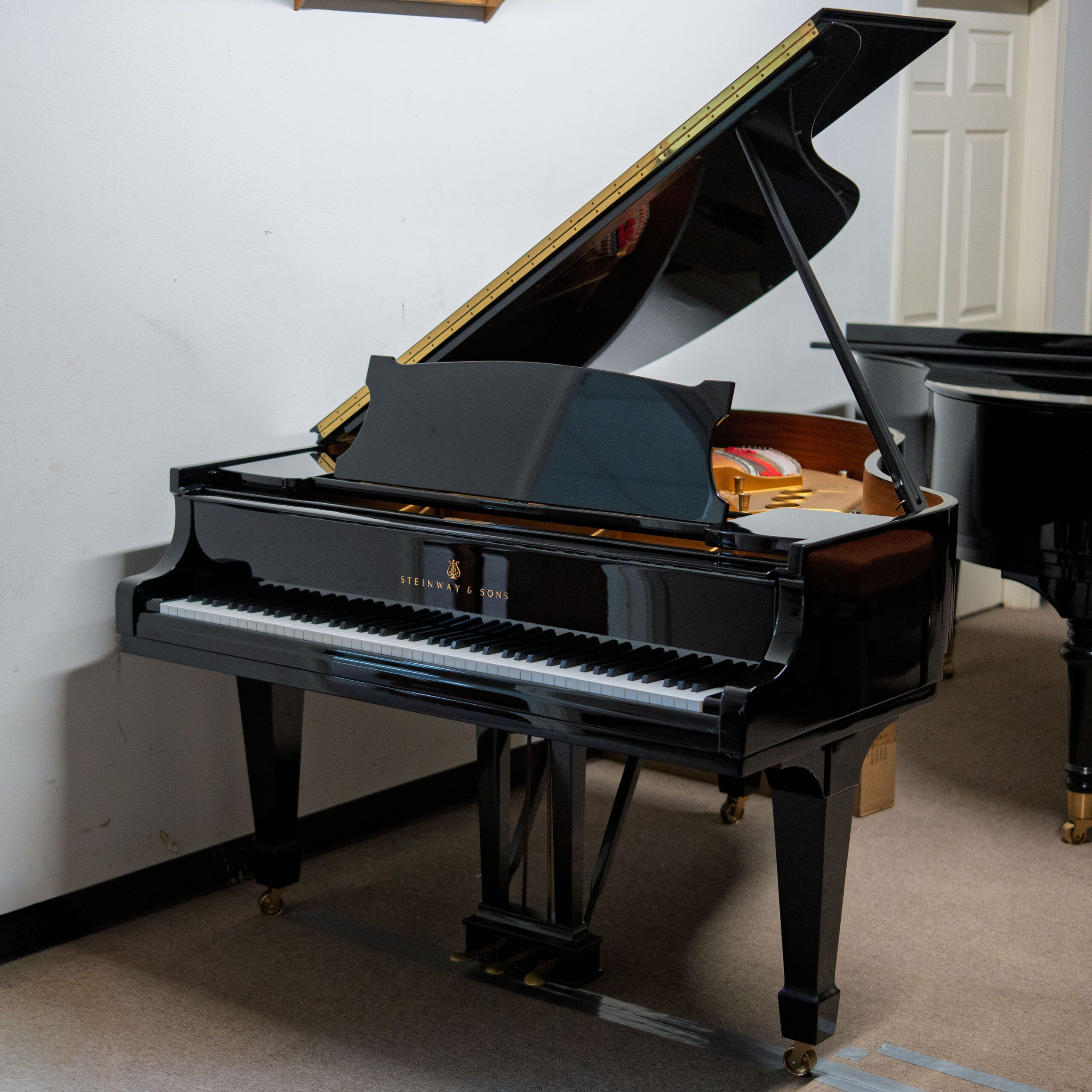 A classic black grand piano in a room corner.