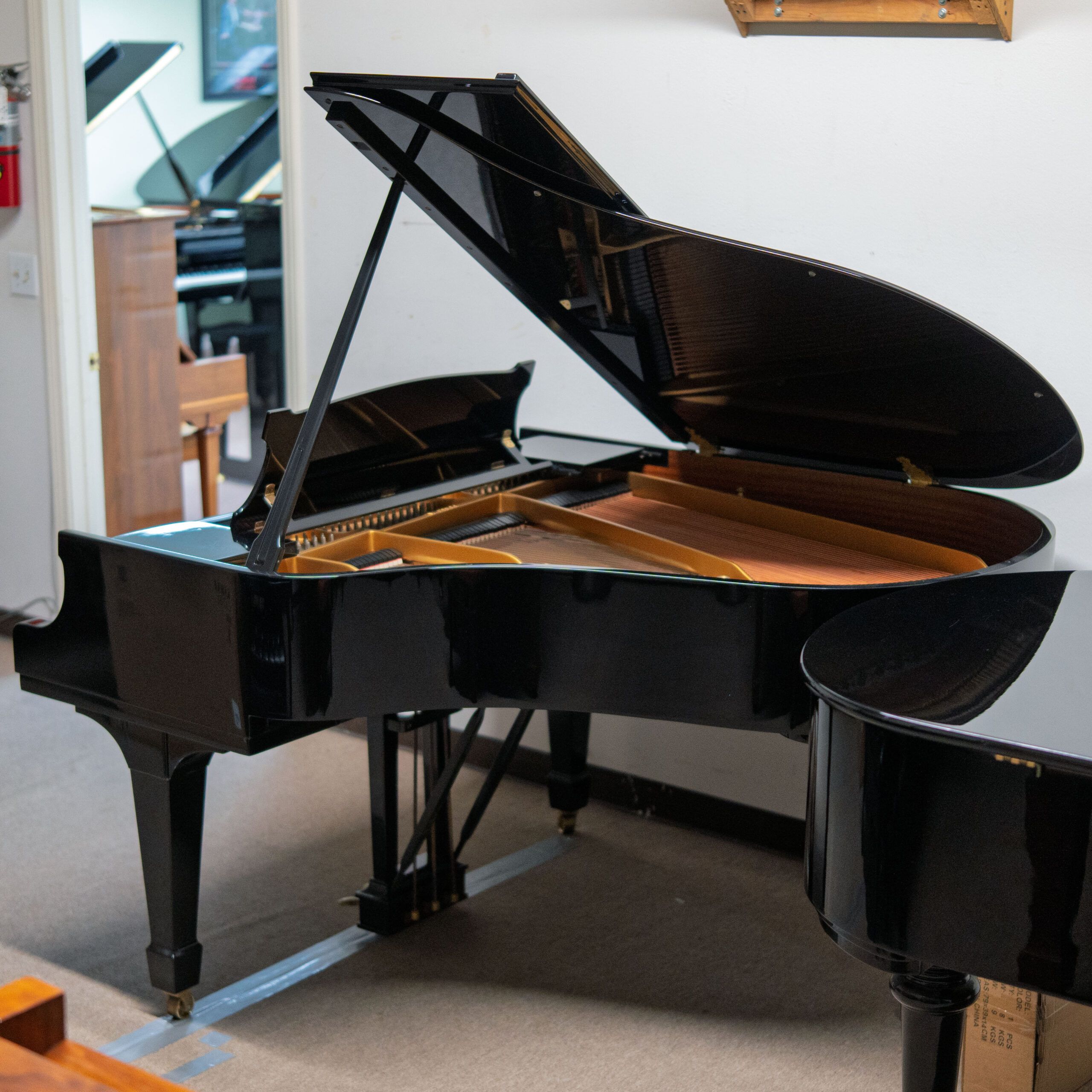 Elegant black grand piano in a bright room.