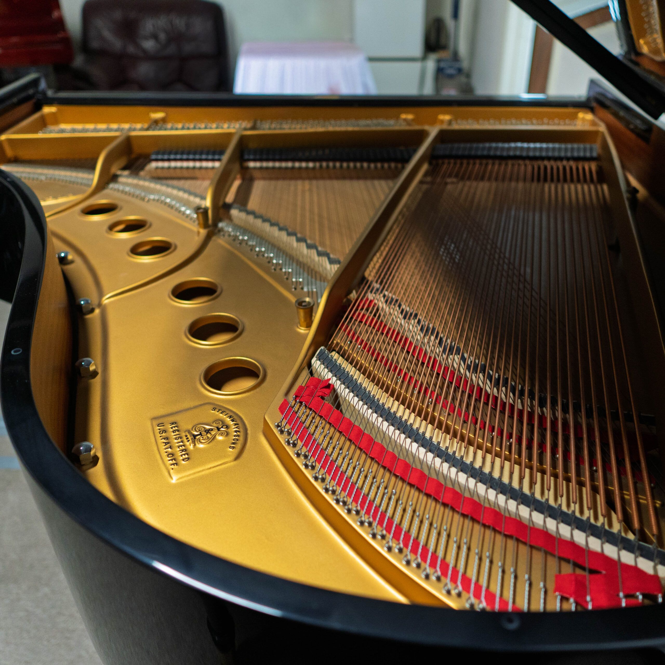 Close-up of a grand piano's strings and frame inside the body.